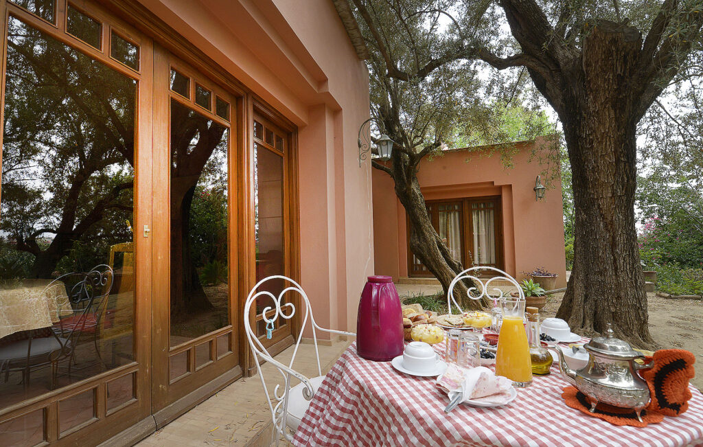 Outdoor Moroccan breakfast table with tea, orange juice and local food at Maroc Lodge near Amizmiz in the Atlas Mountains